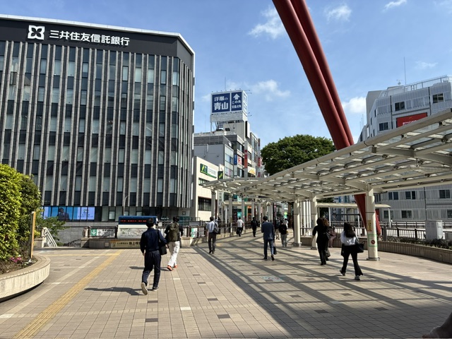 ペデストリアンデッキを進む様子。正面に三井住友信託銀行と洋服の青山