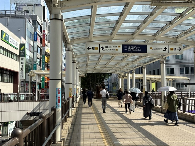 北口デッキの案内表示が見える歩行者通路